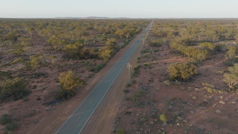 Clip-De-Drone-Que-Muestra-Automóviles-Circulando-Por-Un-Camino-Rural-Aislado-A-Través-Del-Interior-De-Australia