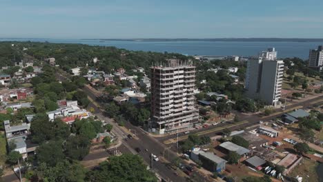 Las-Imágenes-De-Drones-Capturan-El-Tapiz-Dinámico-Del-Desarrollo-Urbano-Cerca-Del-Río-Paraná,-Mostrando-Sitios-De-Construcción,-Carreteras-Bulliciosas,-Tráfico-Vibrante,-Exuberante-Vegetación-Y-Encantadoras-áreas-Residenciales.