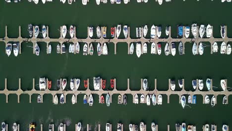 Overhead-shot,-beginning-close-and-moving-away-from-boats-on-a-marina-on-a-sunny-day