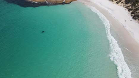 Antena-De-Drones-Sobre-Una-Pequeña-Playa-Con-Agua-Azul-Brillante