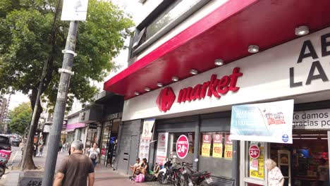 Establishing-shot-At-Carrefour-Supermarket-convenience-store,-people-walk-street-of-buenos-aires-city,-pedestrians-at-commercial-area-neighborhood