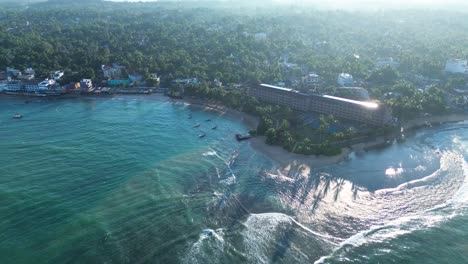 Aerial-drone-landscape-view-of-hotel-resorts-on-Turtle-Beach-sandy-ocean-rocky-reef-bay-coastline-of-Hikkaduwa-Sri-Lanka-Asia-travel-tourism-nature