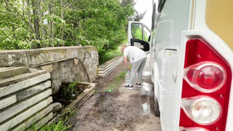 Un-Viajero-En-Autocaravana-Recoge-Agua-Mineral-Natural-Gratuita-Del-Manantial-Del-Pueblo