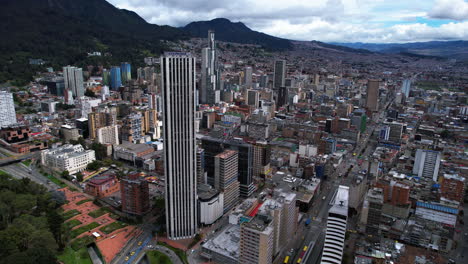 Aerial-view-passing-the-Torre-Colpatria-tower,-sunny-day-in-Bogota,-Colombia