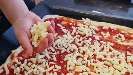 Ein-Kind,-Das-Den-Käse-Auf-Dem-Pizzateig-Verteilt