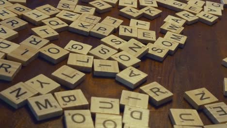 Dolly-Shot-Sanft-Bögen-Vorbei-An-Verschiedenen-Scrabble-Spielsteine-Auf-Holztisch