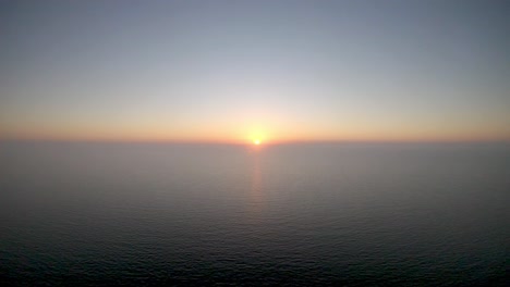 Aerial-4K-Drone-footage-of-the-sun-just-before-it-sets-over-the-sea-off-Calm-Beach,-in-Naples,-Florida,-USA