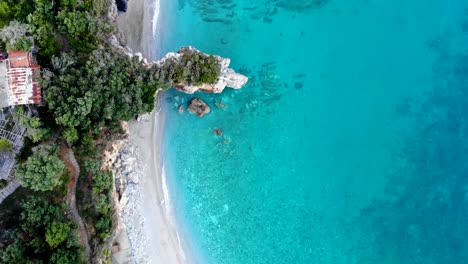 Playa-Bordeada-De-Rocas-Y-Agua-Cristalina-Brilla-En-Hermosos-Colores-Turquesa