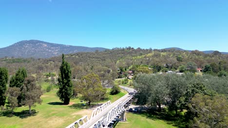 Flying-towards-the-township-of-Tharwa-adjacent-to-the-historic-Allan-truss-Tharwa-Bridge,-across-the-Murrumbidgee-River,-near-Canberra,-Australia