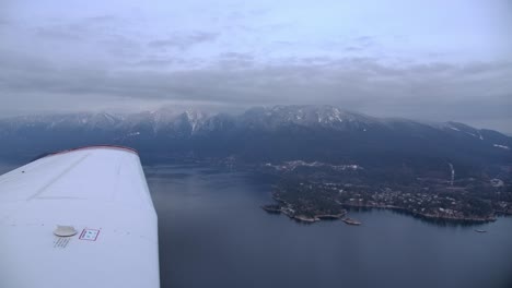 Einmotoriger-Flugzeugflügel-Im-Flug,-Bergküstenhintergrund