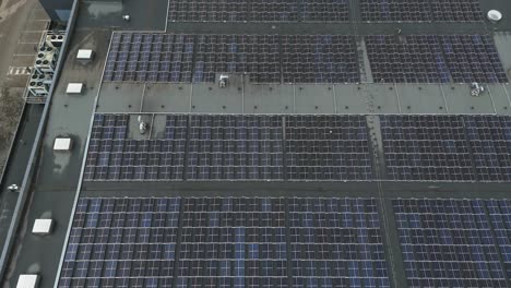 Drohnenaufnahme-Einer-Riesigen-Fläche-Mit-Solarmodulen-Auf-Dem-Dach-Einer-Betonfabrik