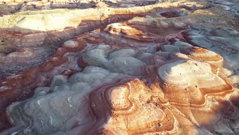 Aerial-4k-drone-flyover-view-of-Bentonite-Hills,-Utah,-at-golden-hour-with-colorful-mars-like-landscape