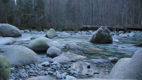 Water-Flowing-Through-Big-Rocks-In-A-River---Wide-Shot