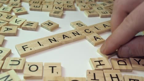 Words-FINANCIAL-and-SCAM-make-crossword-in-Scrabble-letter-tiles