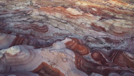 Aerial-4k-drone-flyover-view-of-Bentonite-Hills,-Utah,-at-golden-hour-with-colorful-mars-like-landscape