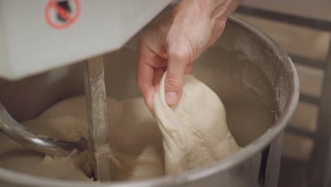 Chef-checking-viscosity-of-a-dough-in-an-electric-mixer