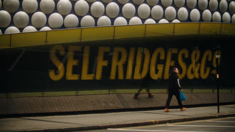A-man-walks-past-the-signage-for-Selfridges-in-Birmingham-UK