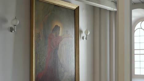 Light-reflecting-off-painting-of-Jesus-Christ,-hanging-in-old-Lutheran-Church