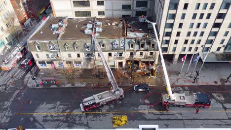 Vista-Aérea-Descendente-Sobre-Los-Bomberos-Que-Atienden-Múltiples-Incendios-En-Un-Edificio-En-Montreal,-Canadá