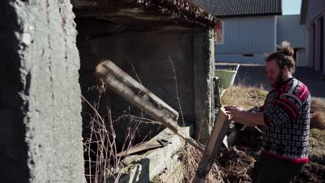 The-Man-is-Removing-the-Old-Support-Post-on-the-Farm-in-Indre-Fosen,-Trondelag-County,-Norway---Static-Shot