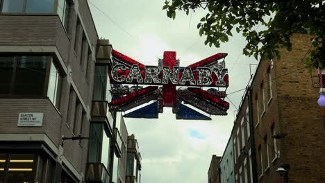 Carnaby-Schild-Hängt-In-Der-Luft---Union-Jack,-Carnaby-Street,-London,-Tag,-Niedriger-Winkel,-Ganton-Straßenschild