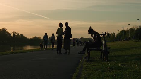 Sonnenuntergang-Am-Jarun-See,-Zagreb,-Mit-Menschen-Und-Radfahrern,-Die-Den-Abend-Genießen