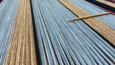 Yarn-thread-rows-with-weaving-needle-in-closeup-panning-shot