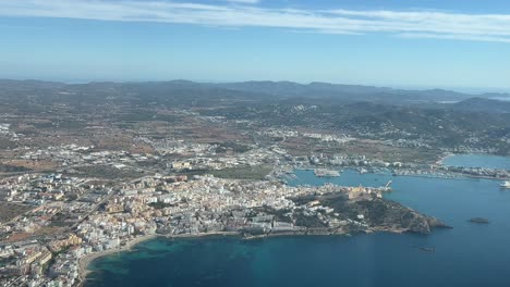 Aerial-view-of-Ibiza-city,-Spain,-shot-from-a-plane-cockpit-departing-from-the-airport