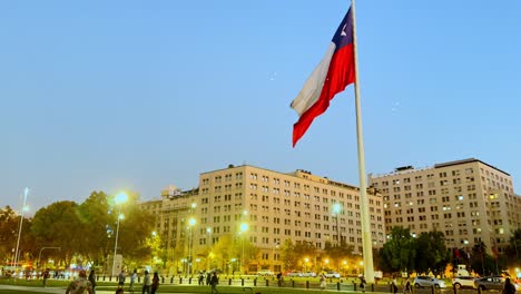 Large-Chilean-flag-at-Avenida-La-Alameda,-colorful-dusk-in-Santiago-de-Chile