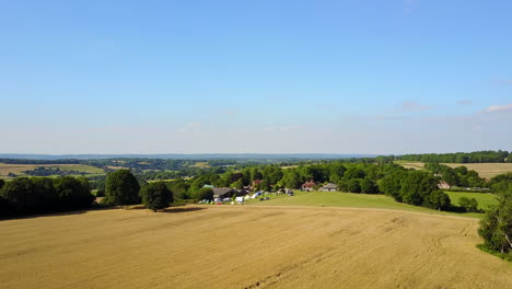 Landschaft-Von-Kent,-Großbritannien-–-Drohne-Fliegt-Bei-Sonnenuntergang-über-Weizenfeld-In-Richtung-Eines-Kleinen-Campingplatzes