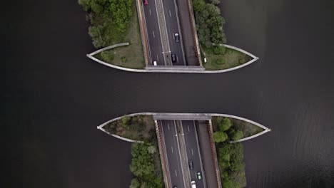Steady-top-down-aerial-showing-highway-with-traffic-passing-underneath-Veluwemeer-aquaduct-seen-from-above