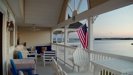 American-Flag-Waves-on-Shore-Town-Porch-at-Sunset-in-Slow-Motion