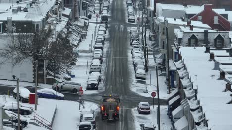 Snow-and-Ice-Control-Service-on-street-in-american-housing-area,-spreading-salt-on-icy-road