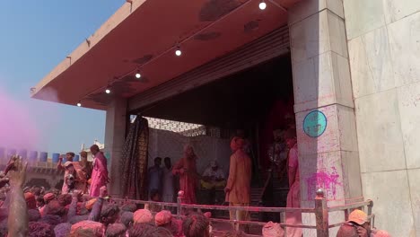 pov-shot-from-inside-the-temple,-men-are-blowing-colors-of-dust-and-men-are-playing-dusty