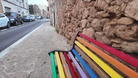 Calle-Algaida-Con-Coloridos-Bancos,-Arquitectura-De-Piedra,-Coches-Estacionados-En-La-Calle-Y-Luz-De-La-Mañana