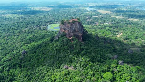 Aerial-drone-landscape-of-Sigiriya-ancient-rock-formation-temple-ruins-on-top-of-cliff-mountaintop-surrounded-by-forest-Sri-Lanka-Kandy-travel-tourism-Asia