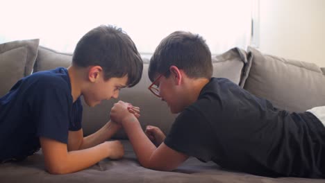 Side-view-tight-shot-of-two-caucasian-boys-playing-armwrestling-at-home-4K