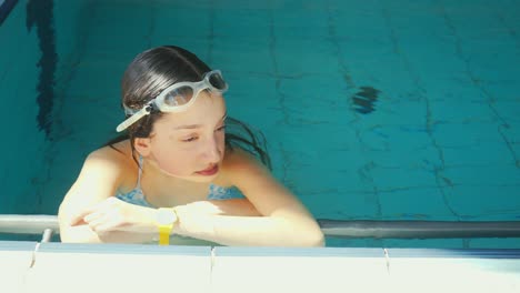 Se-Ve-A-Una-Mujer-Joven-En-Una-Piscina,-Relajándose-Después-De-Nadar.