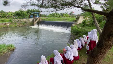 Elementary-school-children-study-on-the-edge-of-a-river-dam