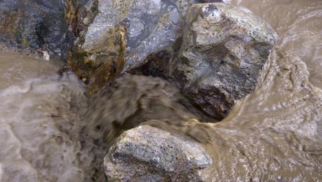 River-of-Fumaroles-Muddy-Waters-in-the-Azores-with-Rocks,-Close-up