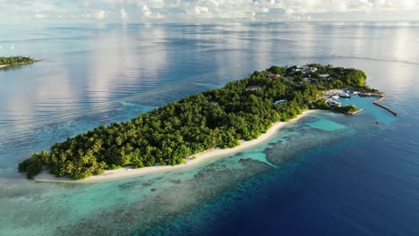 Imágenes-De-Drones-Recorriendo-Lentamente-La-Isla-Local-De-Thinadhoo-Temprano-En-La-Mañana,-Con-Aguas-Cristalinas-En-Las-Maldivas.