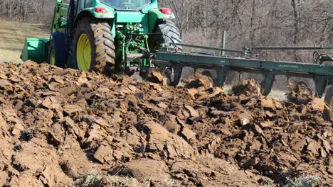 John-Deere-plow-turning-dirt-in-a-alfalfa-field-in-early-spring-in-the-Midwest