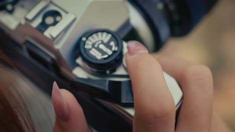 close-up-on-female-hands-with-long-nails-turning-the-film-advance-lever-on-old-vintage-retro-film-camera