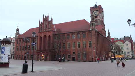 People-walking-through-courtyard-outside-Torun-Regional-Museum,-Poland