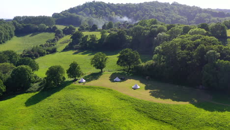 Aerial-tilting-away-Great-Oaks-Glamping-Sunny-day-UK-4K
