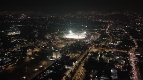 Birds-eye-perspective-of-brightly-lit-Estadio-Olimpico-Universitario,-prepared-for-soccer-matches,-during-the-evening-hours