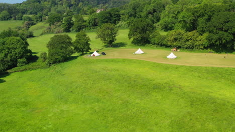 Aerial-flying-over-treetops-Great-Oaks-Glamping-Sunny-day-UK-4K