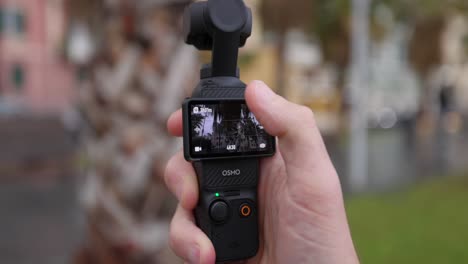 Hand-Operating-the-Display-Touchscreen-Of-DJI-Osmo-Pocket-3