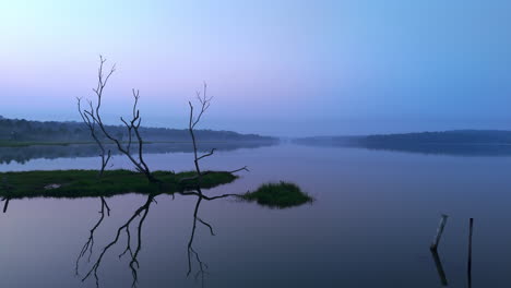 Morgens-Ruhiger-See,-Vor-Sonnenaufgang-Spiegelt-Sich-Der-See-In-Den-Atmosphärischen-Effekten-Des-Himmels-Und-Ist-Von-Nebligen-Nebeln-Umgeben