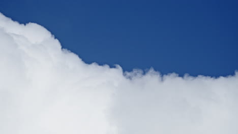 La-Nube-Blanca-Pura-Cambia-Lentamente-De-Forma-En-El-Cielo-Azul,-Vista-Telescópica-Abstracta